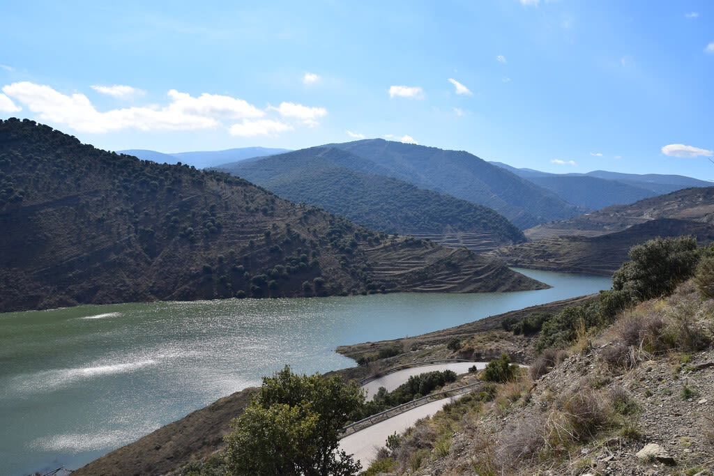 Impresión aérea de un embalse con niveles de agua visiblemente bajos, revelando la orilla seca.