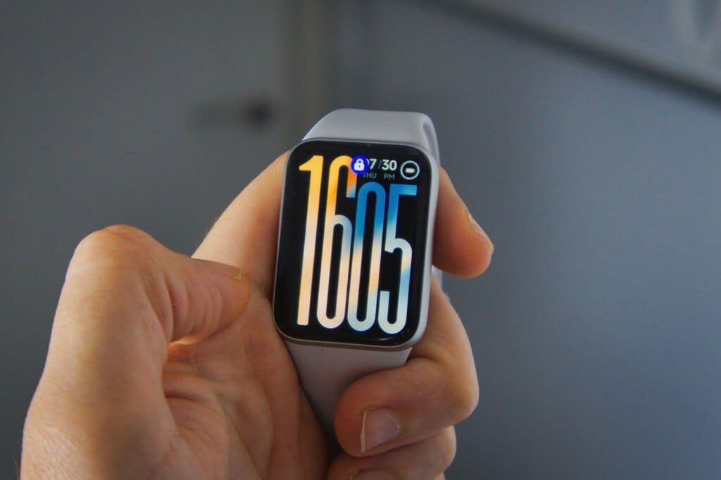 Xiaomi Smart Band 10 Pro NFC on a wrist with a bright AMOLED screen displaying notifications.