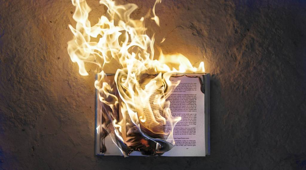 Un estante de libros antiguos siendo escaneado por una luz brillante, con un toque de tecnología futurista.