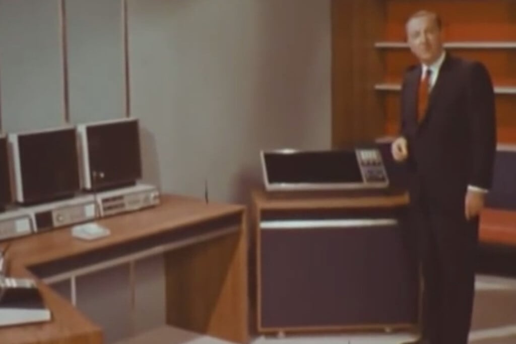 Un televisor antiguo mostrando una sala de oficina futurista con consolas y pantallas.