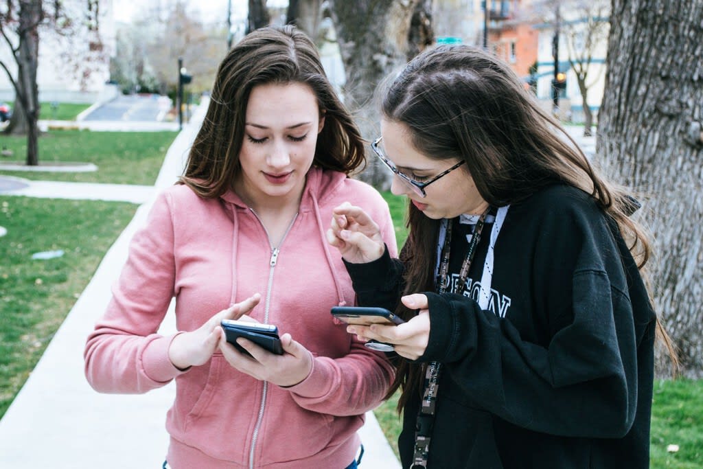 Persona mirando un smartphone con un fondo abstracto de líneas de código y notificaciones difuminadas