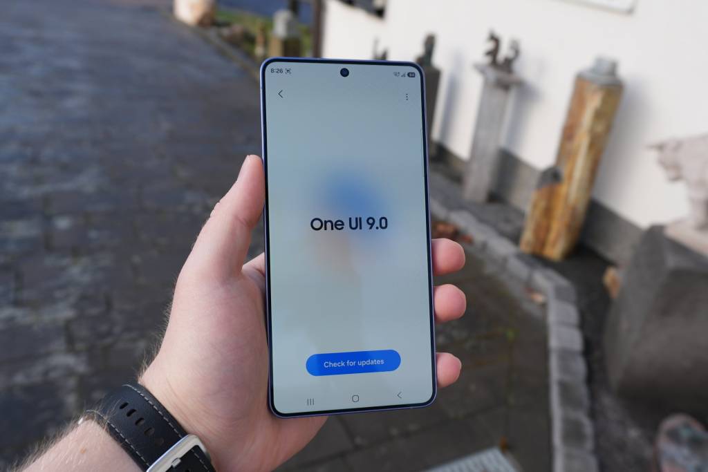 Un smartphone Samsung moderno mostrando la interfaz One UI 9 con iconos de Android 17, sobre un fondo tecnológico abstracto.
