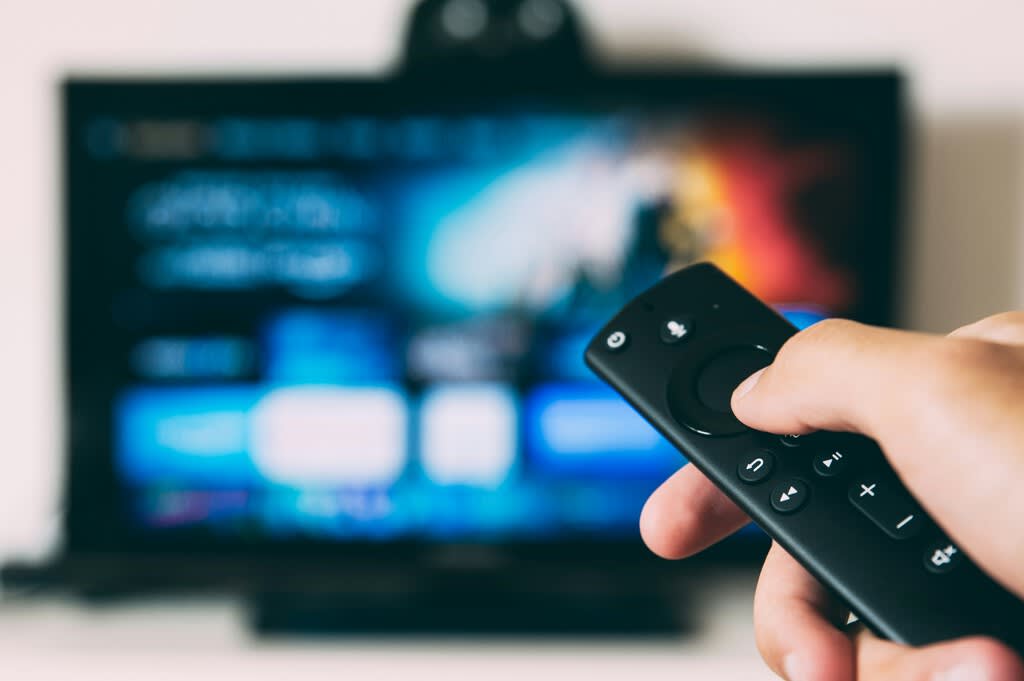A sleek Amazon Fire TV Stick connected to a modern television screen displaying a vibrant streaming interface.