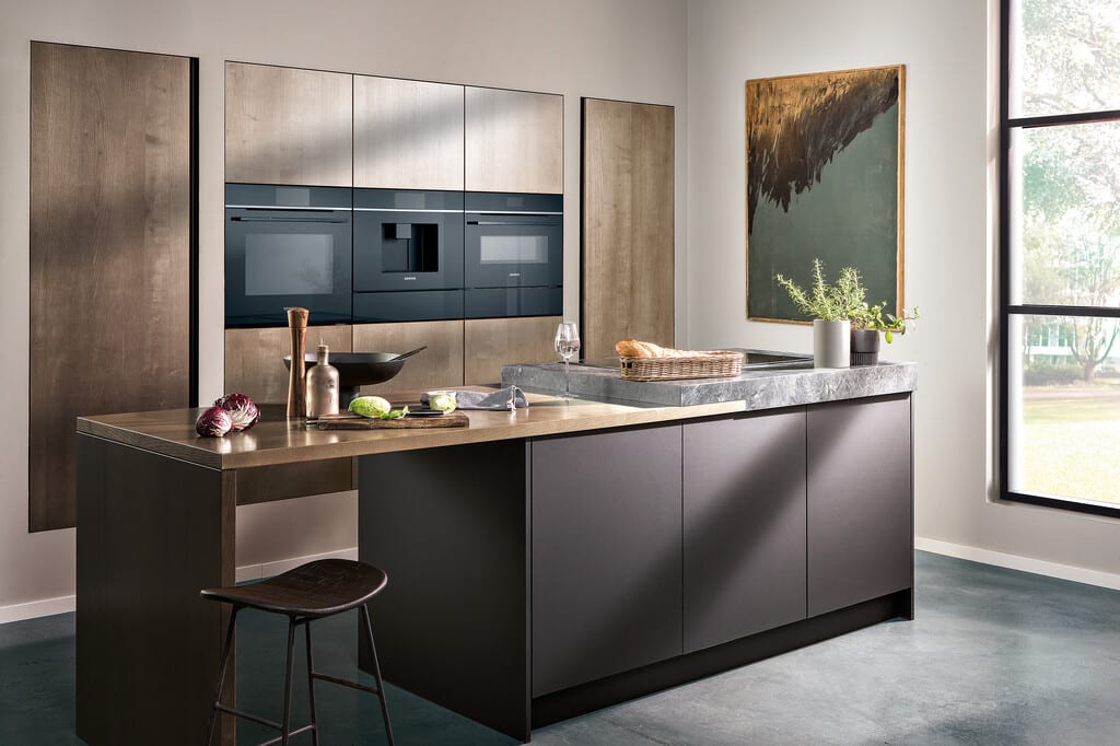 Un conjunto de electrodomésticos Siemens de última generación en una cocina moderna y luminosa, con un horno mostrando una interfaz digital y un frigorífico de gran capacidad.