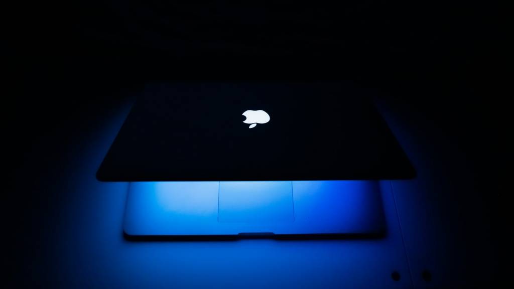 Un escudo estilizado protegiendo un icono de Mac, simbolizando la seguridad de macOS ante la IA.