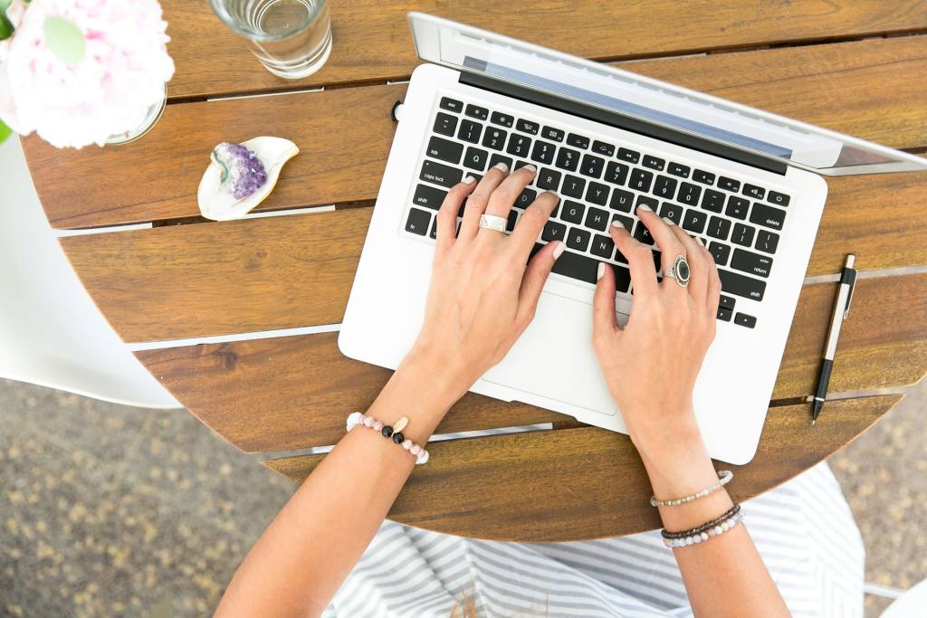 Un portátil MacBook con una interfaz de notas abierta, mostrando elementos de IA sutiles y un icono de Google.