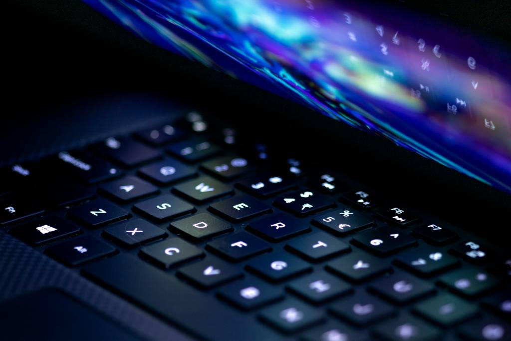 Un monitor OLED mostrando una imagen vibrante con contraste profundo, con el logo de Windows sutilmente integrado.