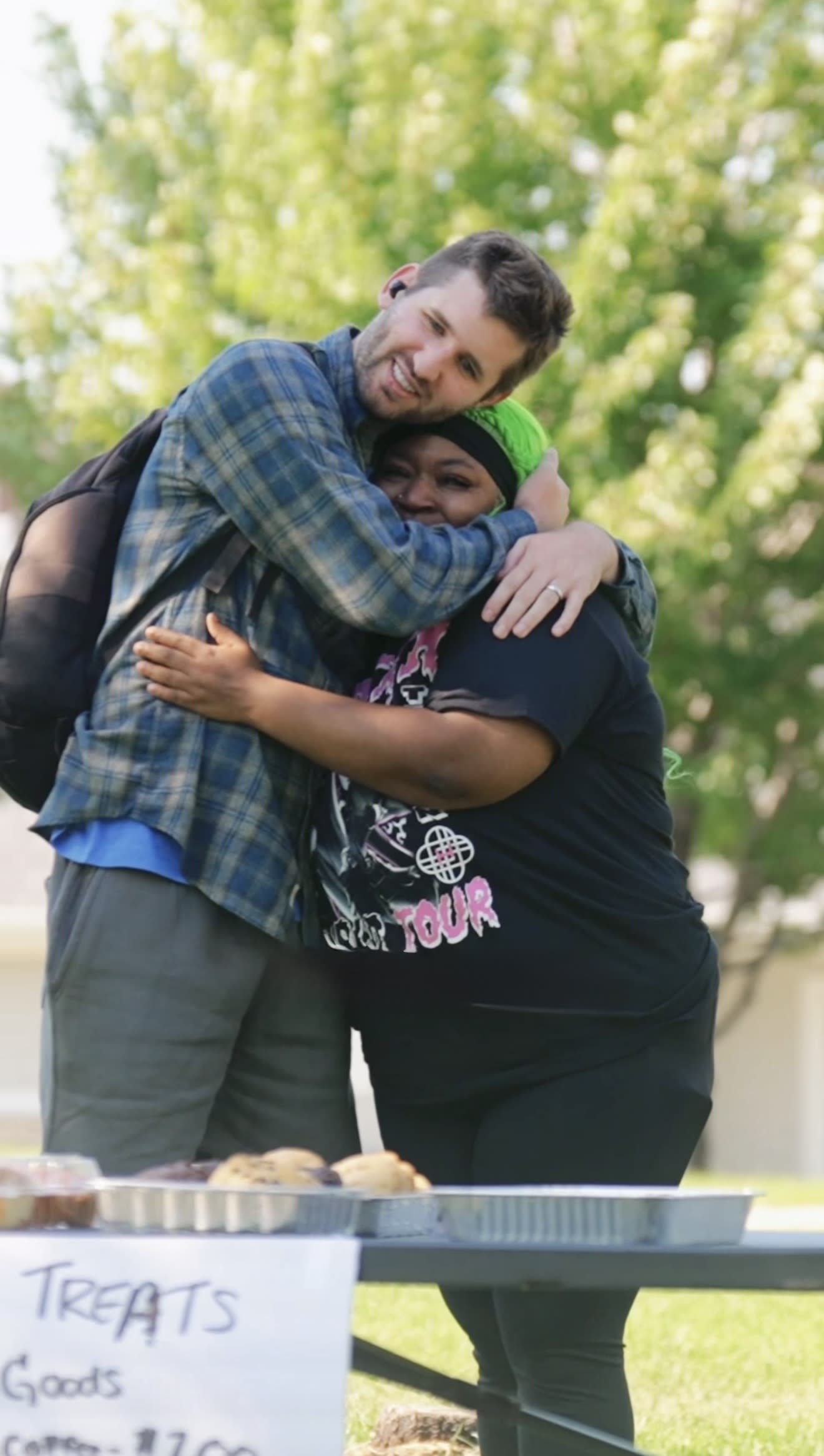 Josh Liljenquist hugging a woman at her food stand during the P.F. Chang’s National Fortune Cookie Day community campaign.