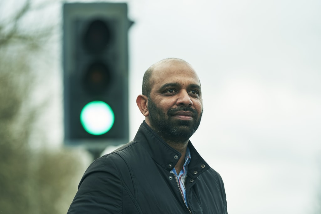 A man standing in front of a traffic light