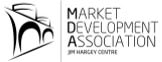 Logo of the Market Development Association featuring stylized building arches beside the text "Market Development Association Jim Harvey Centre" in black font.