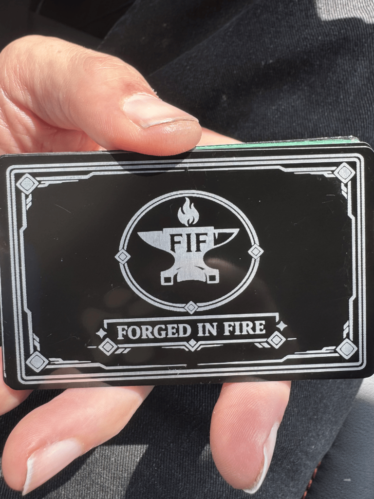 Back of a Forged in Fire engraved metal card held in hand