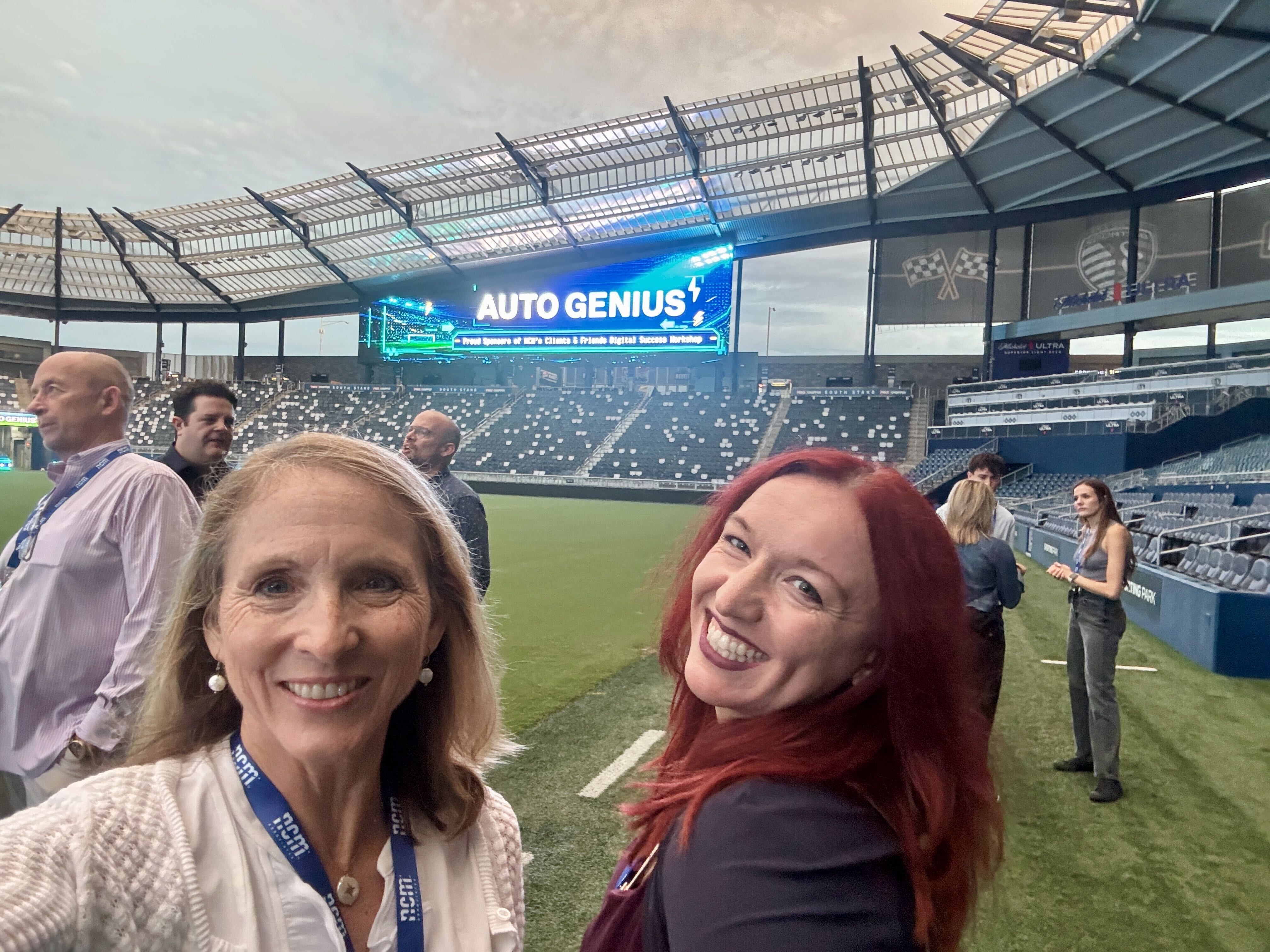 Jen Sanford and Tracy Camacho smiling on the field at Sporting KC Park. 2026 NCM Clients & Friends Digital Success Workshop.