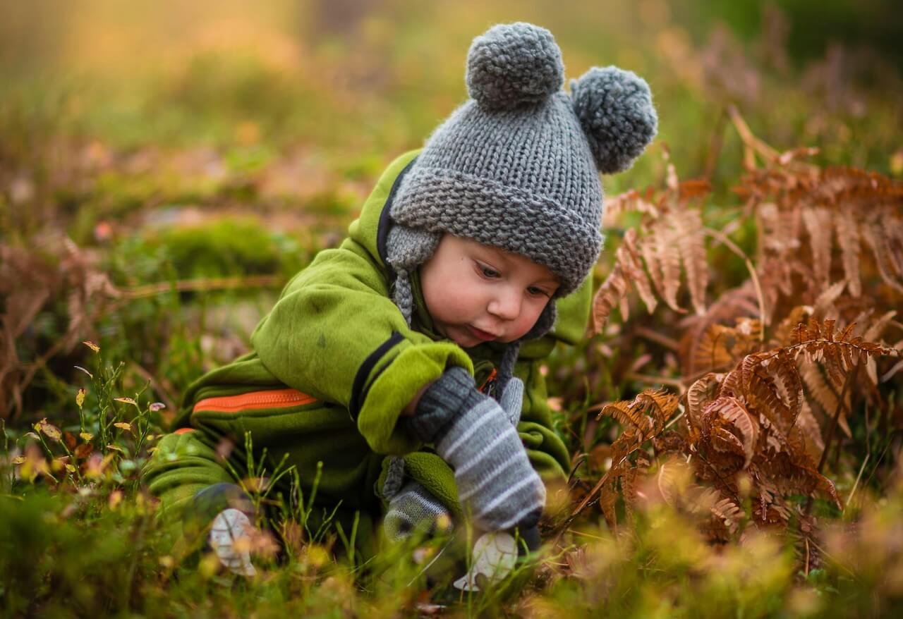 Babies engaged in outdoor sensory play with appropriate toys