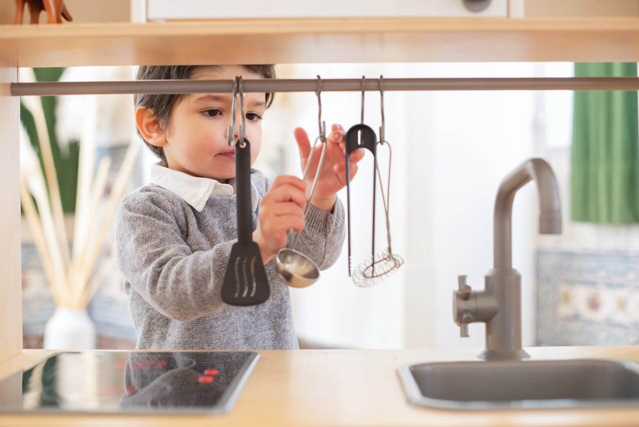 Toddler playing with a colorful and safe kitchen set