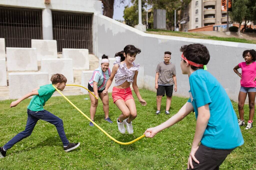 Children playing tag in a sunny backyard garden, promoting active outdoor games for preschoolers