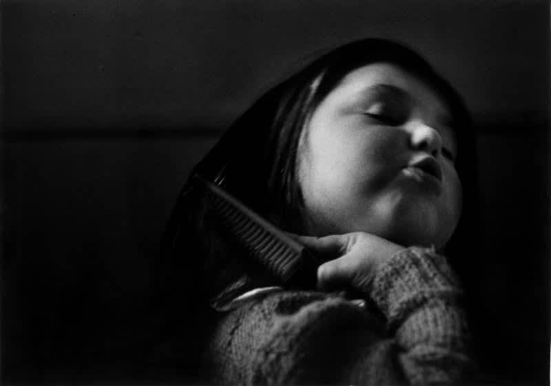 Black and white photo of Gabriel Cuallado, entitled Girl brushing her hair (Family)