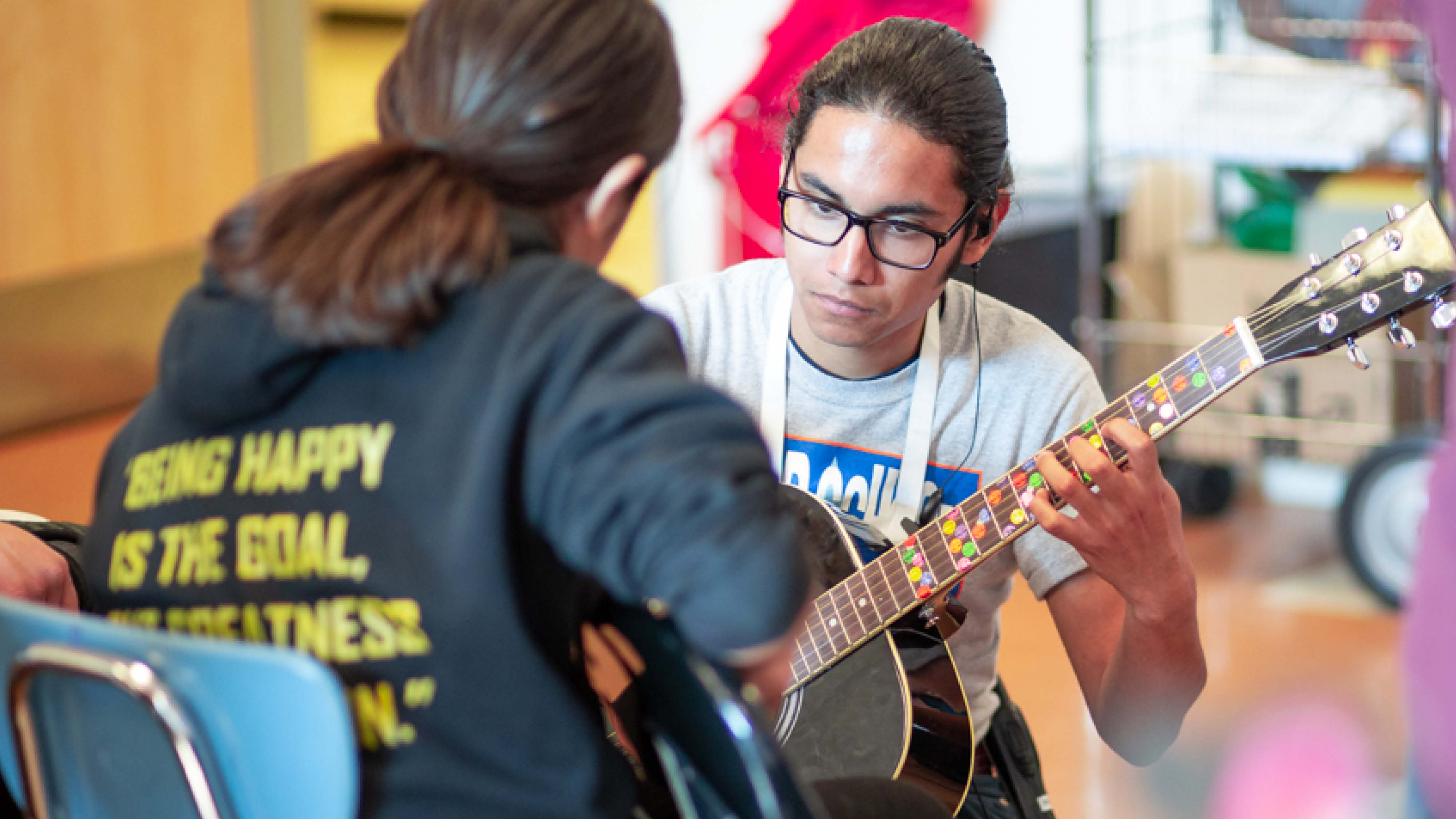 Student learns guitar in after-school music lesson