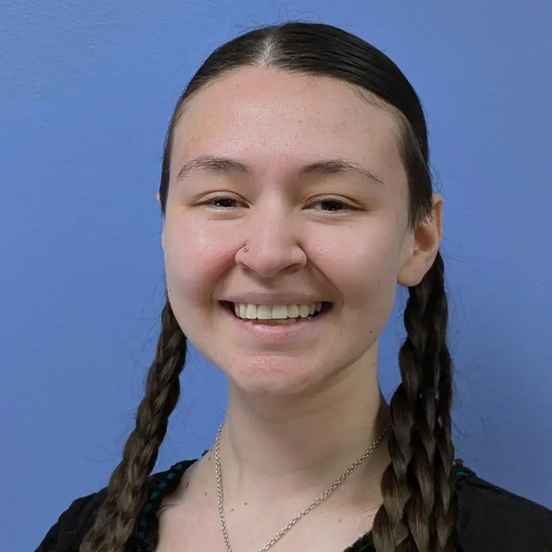 A woman wearing braids smiles