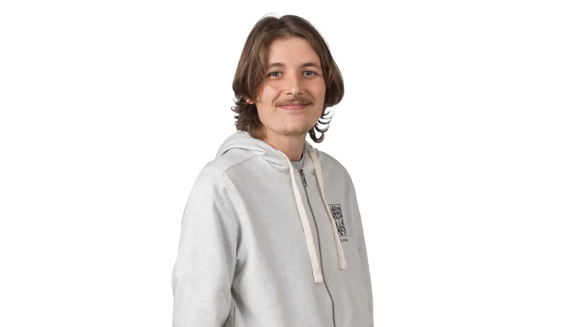 A man in a grey hoodie smiles against a white background