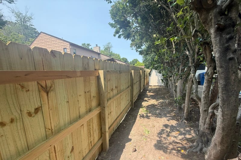 Wood privacy fence installed between mature trees in Virginia Beach VA by Kempsville Fence — photo 4