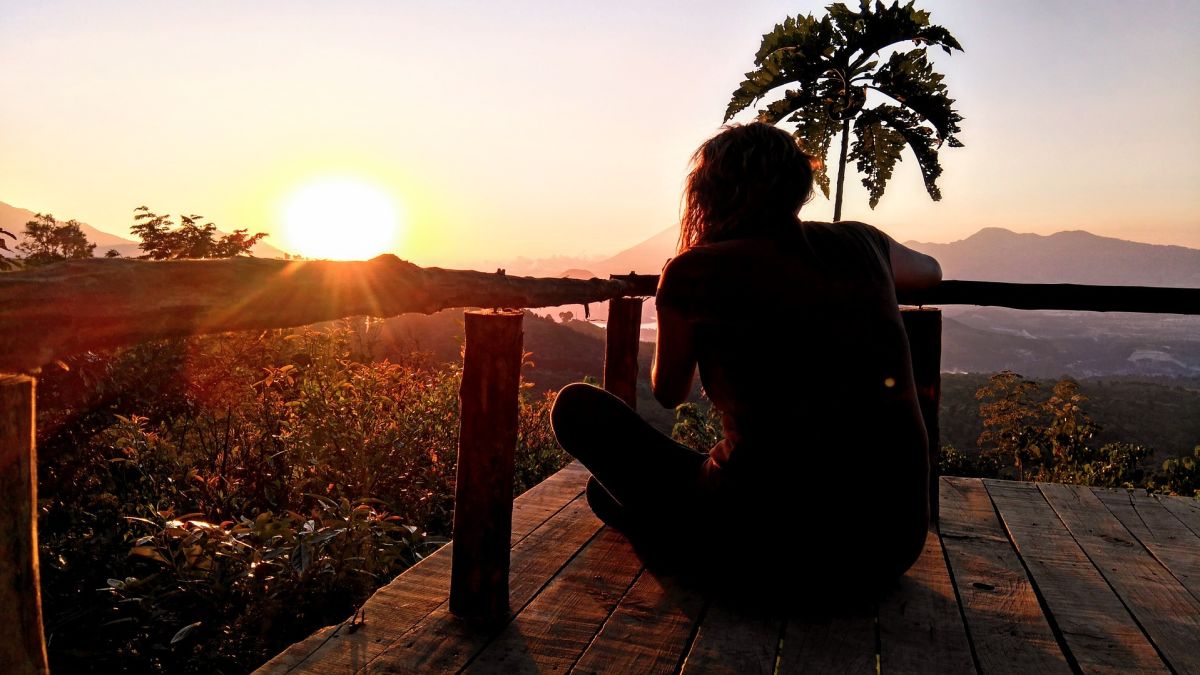 Relaxing in sunset: Woman meditating peacefully