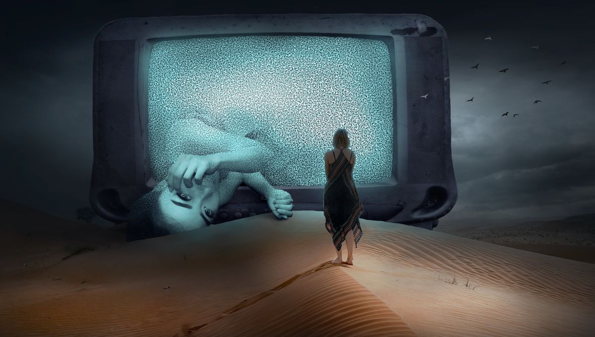 Dreamy scence: Woman walking on desert-sand into huge TV