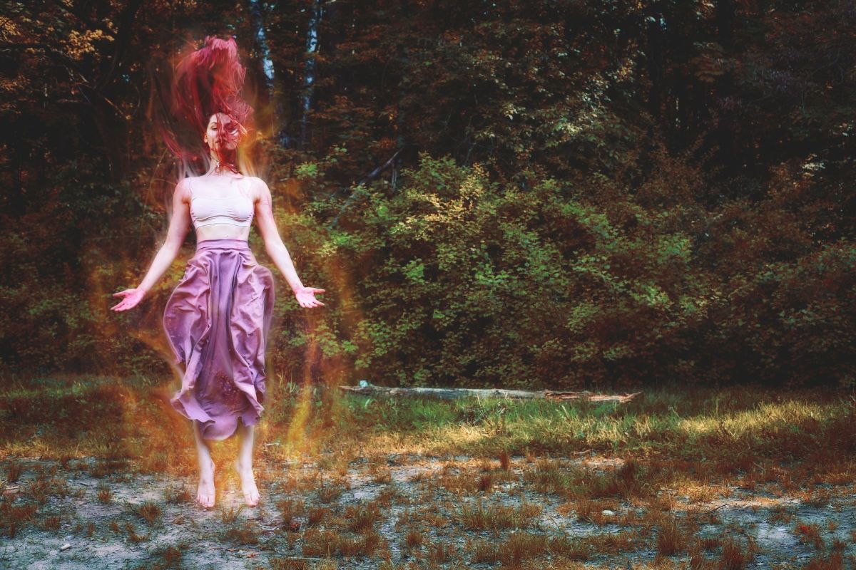 Shamanic woman witch in ecstatic dance over water in jungle