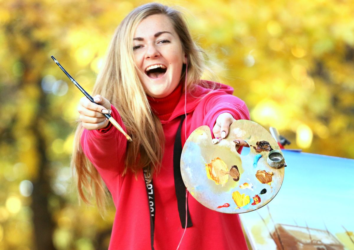 Woman: Ecstatic artist holding palette with colors