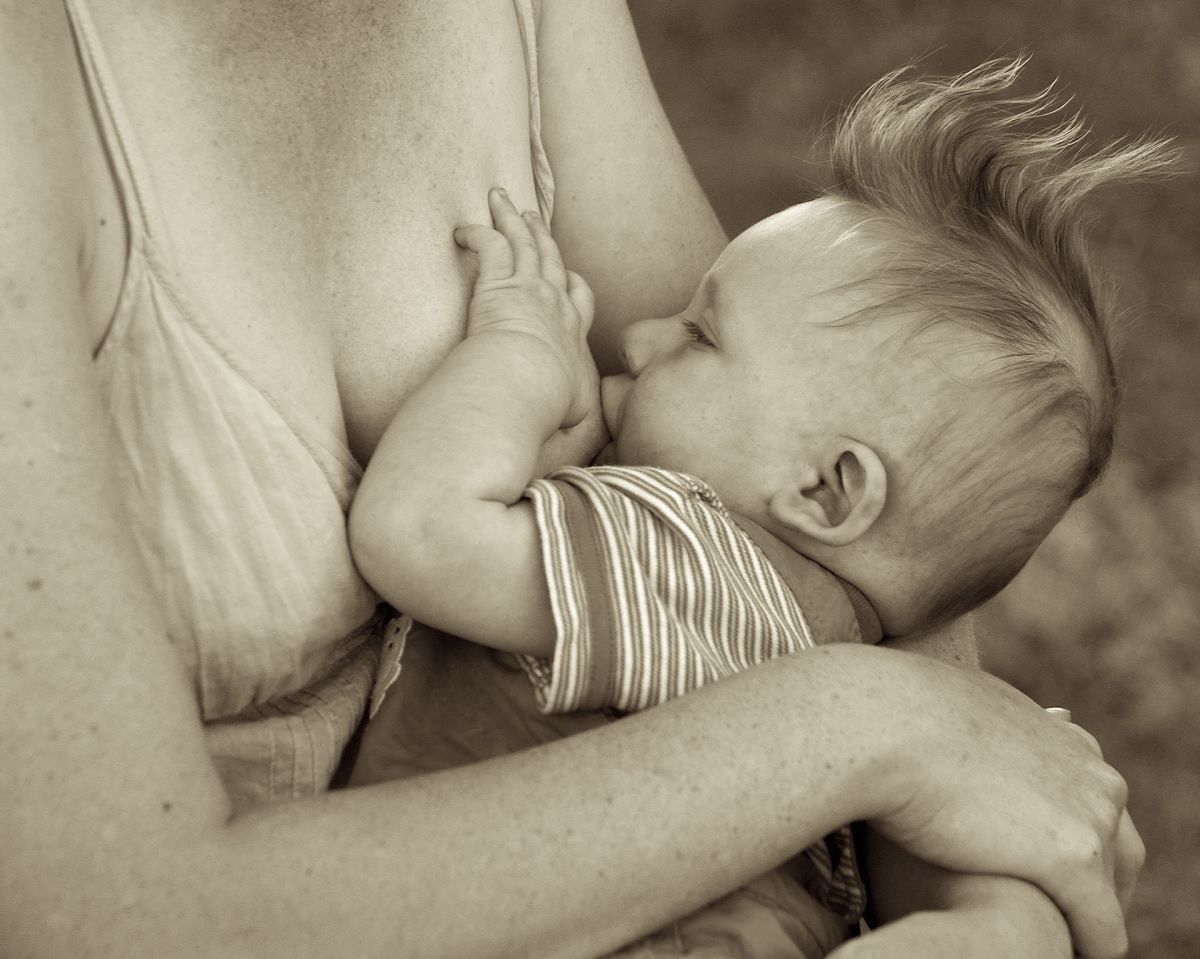 Mother breastfeeding her baby with funny hair