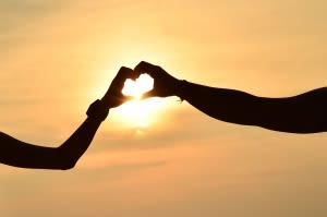 Love: Hands create a heart in the sunset