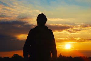 Man looking into sunset.