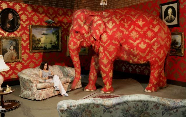 Red elephant in a room with a woman