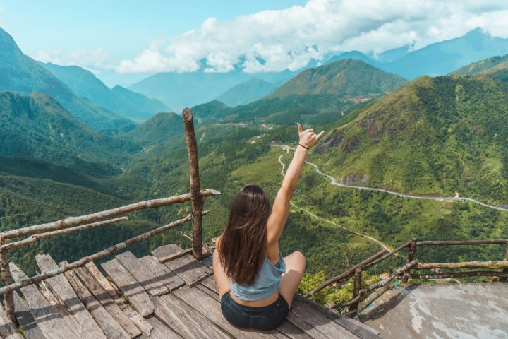 woman on mountain, hand-sign