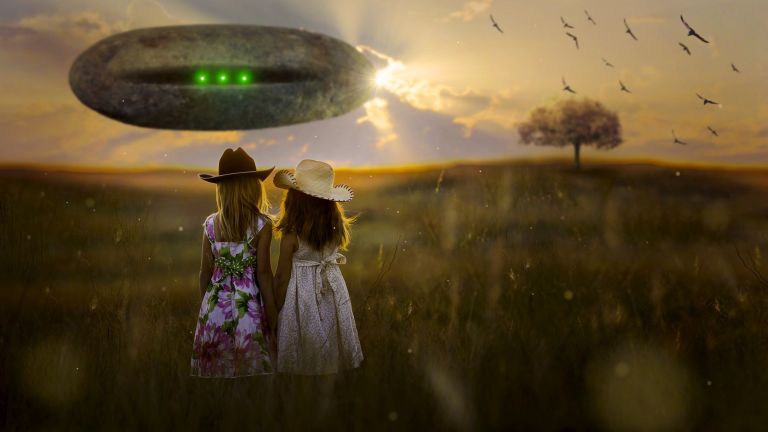 Girls walking in crop circle field with UFO.