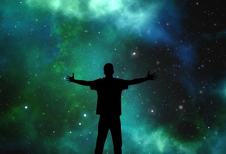 Man holding out hands in universe, stars, nebula, galaxy