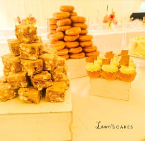 Wedding cake: A table with a bunch of pastries and a stack of pastries