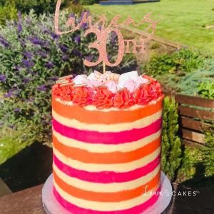 Celebration cake: A pink and orange striped cake topper