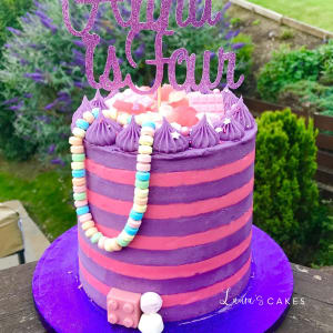 Celebration cake: A purple cake with a pink and purple striped cake topper