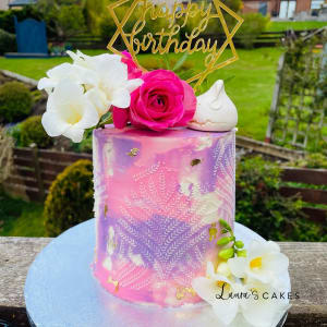 Celebration cake: A pink and purple om om cake topper