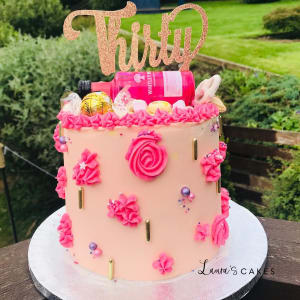 Celebration cake: A pink cake with gold letters and flowers