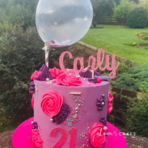 Celebration cake: A pink cake with a balloon and a pink rose