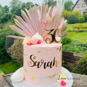 Celebration cake: A pink cake with feathers and a gold number