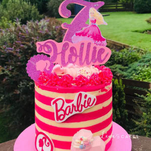 Celebration cake: A pink and yellow cake with a unicorn on top