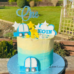 Celebration cake: A blue and yellow cake with a little boy ' s name on top