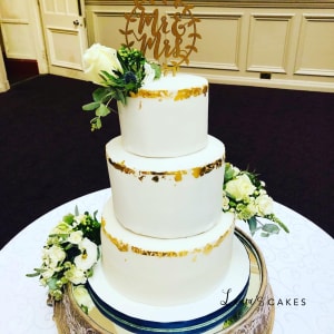 Wedding cake: A white cake with gold and green decorations
