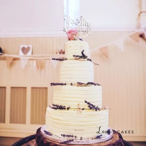 Wedding cake: A white frosting and purple flowers