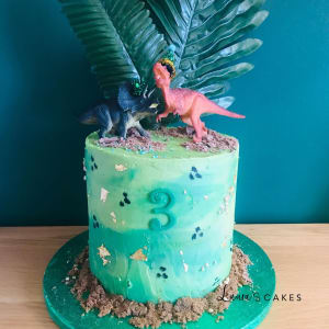 Celebration cake: A dinosaur cake with a green frosting and a pink dinosaur
