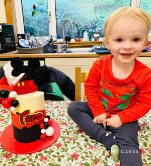 Celebration cake: A little boy sitting on a table with a cake