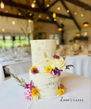 Wedding cake: A white wedding cake with yellow and purple flowers