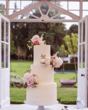 Wedding cake: A white wedding cake with pink flowers on top